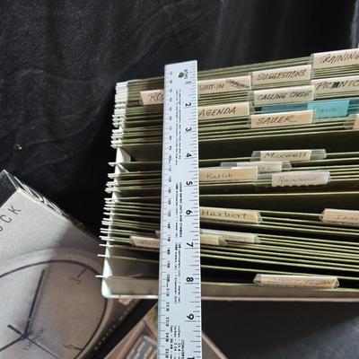 File box with new packages of folders and a nice wall clock