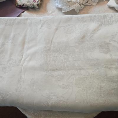 LOT 150: Linens Including Rectangle Tablecloths, Small Round Table Clothes, Table Scarves, Napkins, and More