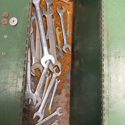Green metal toolbox with wrenches