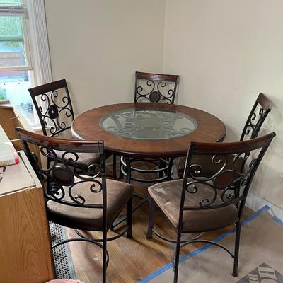 Sale Photo Thumbnail #26: Dark brown dining table with 5 matching chairs. Center has a glass inlay that shows off the table’s rustic design. 

Table has a superficial crack and a visible scratch in it as shown in the pictures. The crack has no impact on the integrity of the tabl