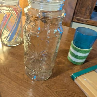 Large basket with jars, vintage party coasters, and other baskets.