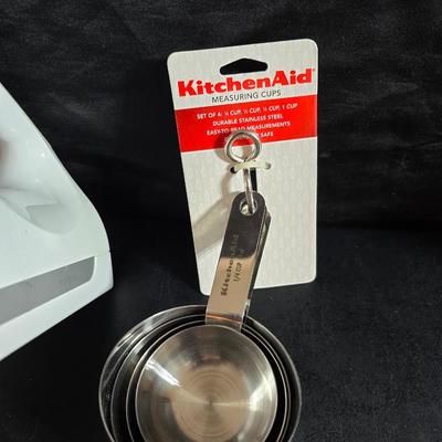 KitchenAid handmixer with new KitchenAid measuring cups, stainless spoons, and a nice stainless bowl