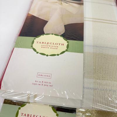 LOT 121: 4 NIP Oblong Golden Plaid and Snowflake Table Cloths