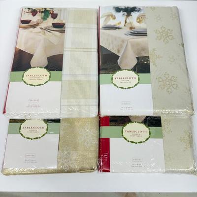 LOT 121: 4 NIP Oblong Golden Plaid and Snowflake Table Cloths