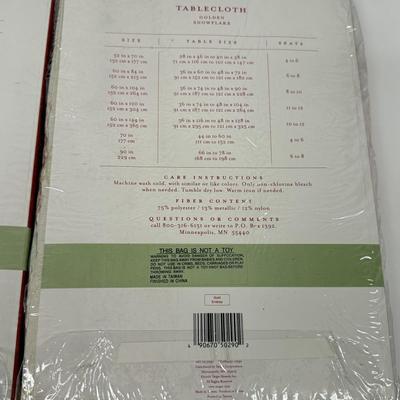 LOT 121: 4 NIP Oblong Golden Plaid and Snowflake Table Cloths