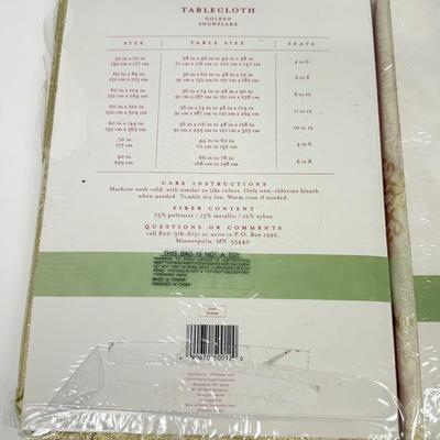 LOT 121: 4 NIP Oblong Golden Plaid and Snowflake Table Cloths