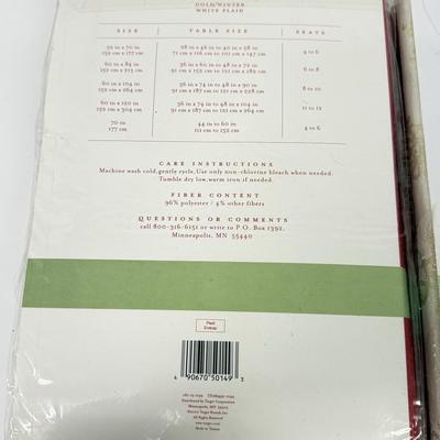 LOT 121: 4 NIP Oblong Golden Plaid and Snowflake Table Cloths