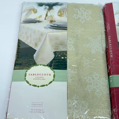 LOT 121: 4 NIP Oblong Golden Plaid and Snowflake Table Cloths