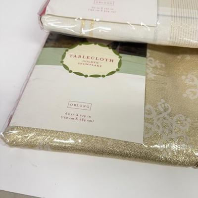 LOT 121: 4 NIP Oblong Golden Plaid and Snowflake Table Cloths