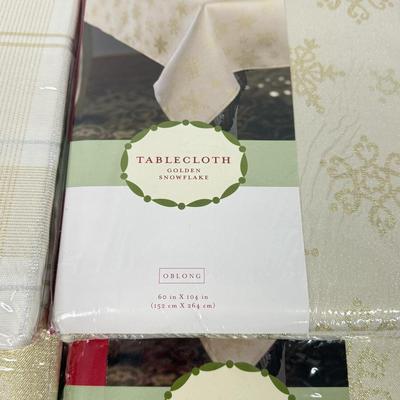 LOT 121: 4 NIP Oblong Golden Plaid and Snowflake Table Cloths