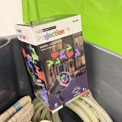 LOT 175: Tote full of White Tube & Red String Lights and a new Gemmy LED Lightshow Projection WHIRL-A-MOTION, heavy duty large tote...