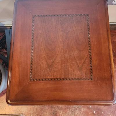 Sale Photo Thumbnail #34: Cherry wood side table featuring turned legs and a decorative inlay on the tabletop. Measures 2 feet in height, 1.6 feet in width, and 2 feet in depth. The table showcases a rich wood grain and classic craftsmanship, ideal for functional or decorative pur