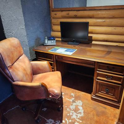Sale Photo Thumbnail #63: Hooker desk crafted from cherry wood, measuring 6 feet in length, 3 feet in width, and 2.6 feet in height. Features include a glass top for added protection, multiple drawers for storage, and elegant carved details. Labeled with Hooker Furniture branding,