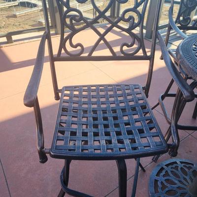 Sale Photo Thumbnail #148: Outdoor bistro set featuring a round table and two armchairs, crafted from cast aluminum with intricate patterns. The table and chairs exhibit matching openwork designs with scroll and floral motifs. The set is durable and weather-resistant, suitable for 