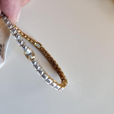 Sale Photo Thumbnail #10: This auction lot is for a Sterling Silver Tennis Bracelet.  The bracelet is new and still sports the maker's tags. It is marked 925. The bracelet has for very light blue stones with raised metal sections between each stone. A very handsome item of jewelry