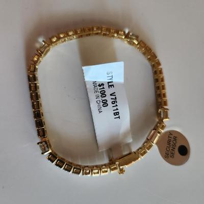 Sale Photo Thumbnail #8: This auction lot is for a Sterling Silver Tennis Bracelet.  The bracelet is new and still sports the maker's tags. It is marked 925. The bracelet has for very light blue stones with raised metal sections between each stone. A very handsome item of jewelry