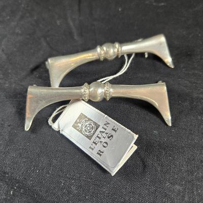Sale Photo Thumbnail #74: This auction lot is for a Pair of Polished Pewter Knife Rests. This a nicely executed Pair of Knife Rests.  They were produced by L'Etain A La Rose.  These were originally sold in fine china shops.  They are very useful in keeping used knives off of the f