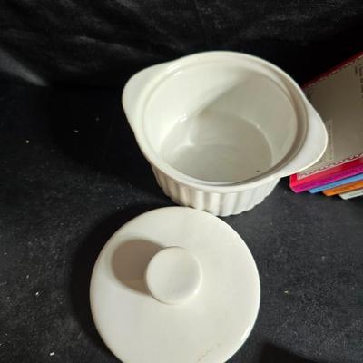 Oven and microwave safe Stoneware dishes with an assortment of themed basket cloths, small cookbooks, and a red pepper salsa dish