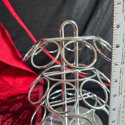 Keurig coffee maker with pod caddy - a red apron - and several Christmas themed mugs.