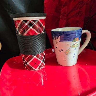 Keurig coffee maker with pod caddy - a red apron - and several Christmas themed mugs.