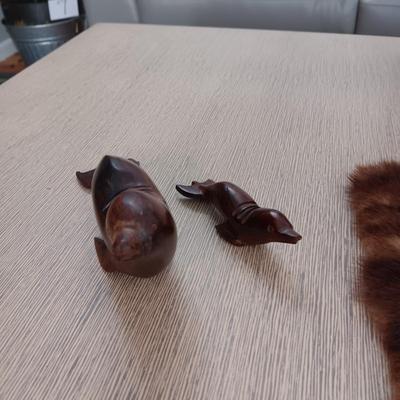 FAUX ORCHID IN CERAMIC POT, CARVED WOODEN SEALS AND AN ANIMAL PELT