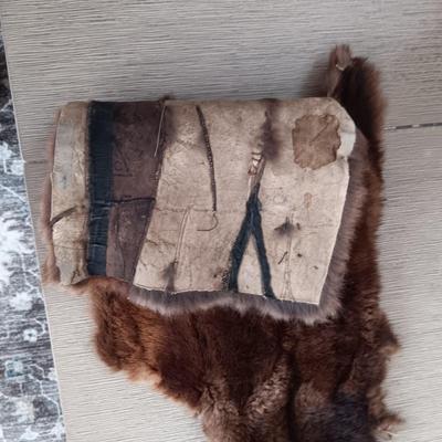 FAUX ORCHID IN CERAMIC POT, CARVED WOODEN SEALS AND AN ANIMAL PELT