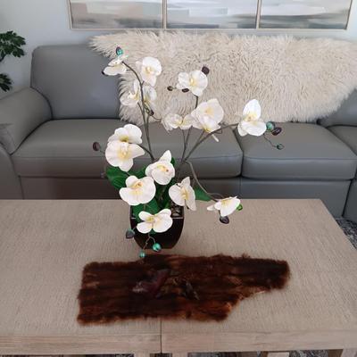 FAUX ORCHID IN CERAMIC POT, CARVED WOODEN SEALS AND AN ANIMAL PELT