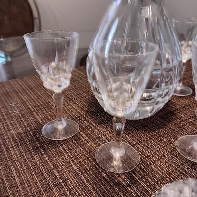 CRYSTAL DECANTER, 5 SMALL STEMMED GLASSES AND CRYSTAL VOTIVE CANDLE HOLDERS
