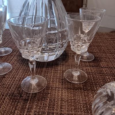 CRYSTAL DECANTER, 5 SMALL STEMMED GLASSES AND CRYSTAL VOTIVE CANDLE HOLDERS