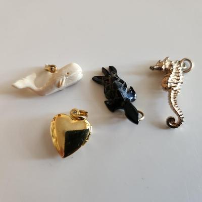Sale Photo Thumbnail #113: This auction lot is for Four Sweet Charms.  This charms where in the bottom of a small dresser jewelry box in a recent estate. There is a small carved white whale, a carved stone turtle, a sea horse and a gold-tone heart locket in this group.