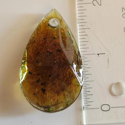 Sale Photo Thumbnail #121: This auction lot is for a Man-made Amber-Like Glass Pendant.  This handsome pendant is drilled and ready for a nice necklace to sport its beauty. See photo for size.