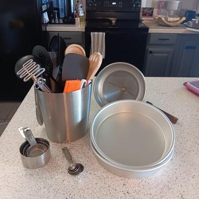 KITCHEN UTENSILS IN A STAINLESS STEEL HOLDER, SIEVE, CAKE PANS, MEASURING CUPS AND SPOONS