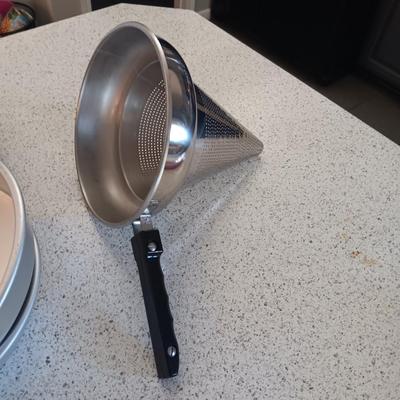KITCHEN UTENSILS IN A STAINLESS STEEL HOLDER, SIEVE, CAKE PANS, MEASURING CUPS AND SPOONS