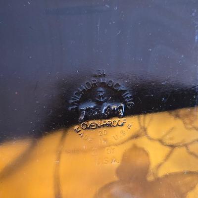 Two amber glass cake pans Fire King - Pyrex and two brand new metal bread loaf pans with a poppy flower tablecloth