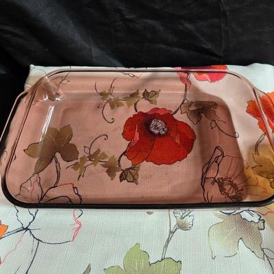Two amber glass cake pans Fire King - Pyrex and two brand new metal bread loaf pans with a poppy flower tablecloth