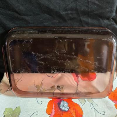 Two amber glass cake pans Fire King - Pyrex and two brand new metal bread loaf pans with a poppy flower tablecloth