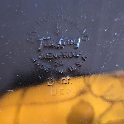 Two amber glass cake pans Fire King - Pyrex and two brand new metal bread loaf pans with a poppy flower tablecloth