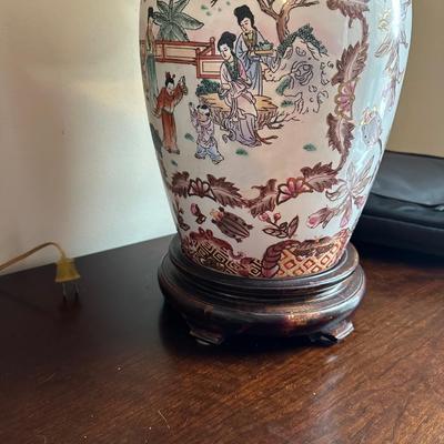 Sale Photo Thumbnail #102: These are a pair of vintage Chinese-style porcelain ginger jar table lamps, featuring hand-painted Chinoiserie motifs of figures and florals on a wooden base.
