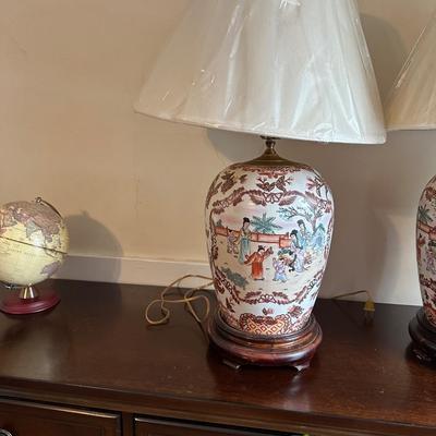 Sale Photo Thumbnail #101: These are a pair of vintage Chinese-style porcelain ginger jar table lamps, featuring hand-painted Chinoiserie motifs of figures and florals on a wooden base.