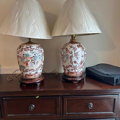 Sale Photo Thumbnail #100: These are a pair of vintage Chinese-style porcelain ginger jar table lamps, featuring hand-painted Chinoiserie motifs of figures and florals on a wooden base.