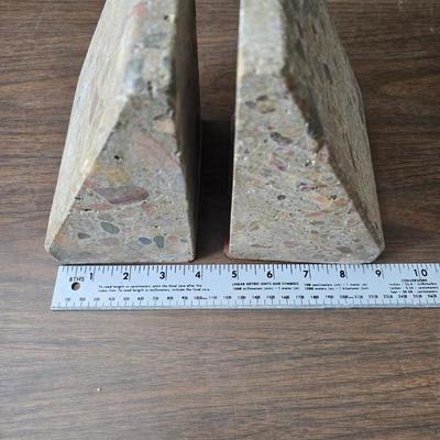 Wedge-shaped fossil stone bookends with a collection of vintage books