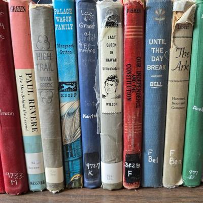 Wedge-shaped fossil stone bookends with a collection of vintage books