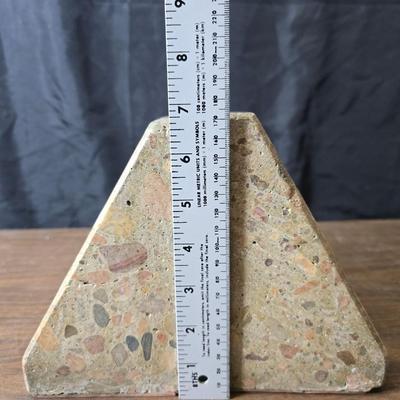 Wedge-shaped fossil stone bookends with a collection of vintage books
