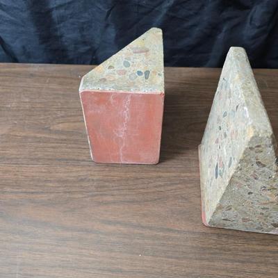Wedge-shaped fossil stone bookends with a collection of vintage books