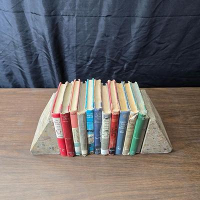 Wedge-shaped fossil stone bookends with a collection of vintage books
