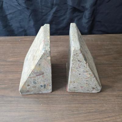 Wedge-shaped fossil stone bookends with a collection of vintage books