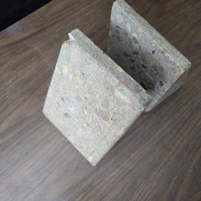 Wedge-shaped fossil stone bookends with a collection of vintage books