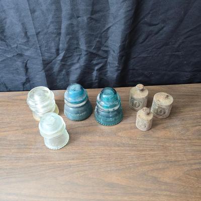 Old glass insulators and three vintage cast iron scale weights