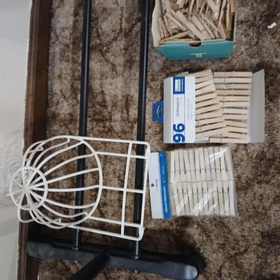 Portable clothes rack with packages of brand-new and opened clothes pins and a baseball cap cleaning tool