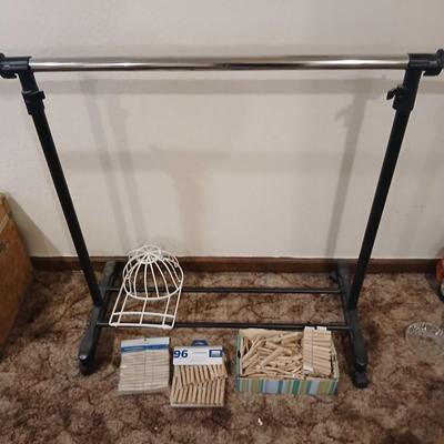 Portable clothes rack with packages of brand-new and opened clothes pins and a baseball cap cleaning tool